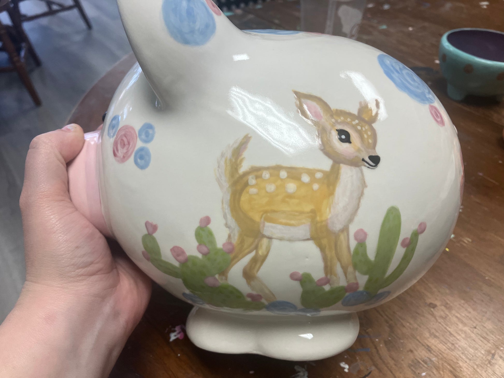 picture shows hand painted deer and cactus on piggy bank