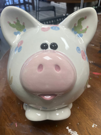 Decorative pig-shaped container with floral patterns on a wooden surface